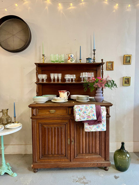 buffet en bois foncé ancien avec de la vaisselle dessus