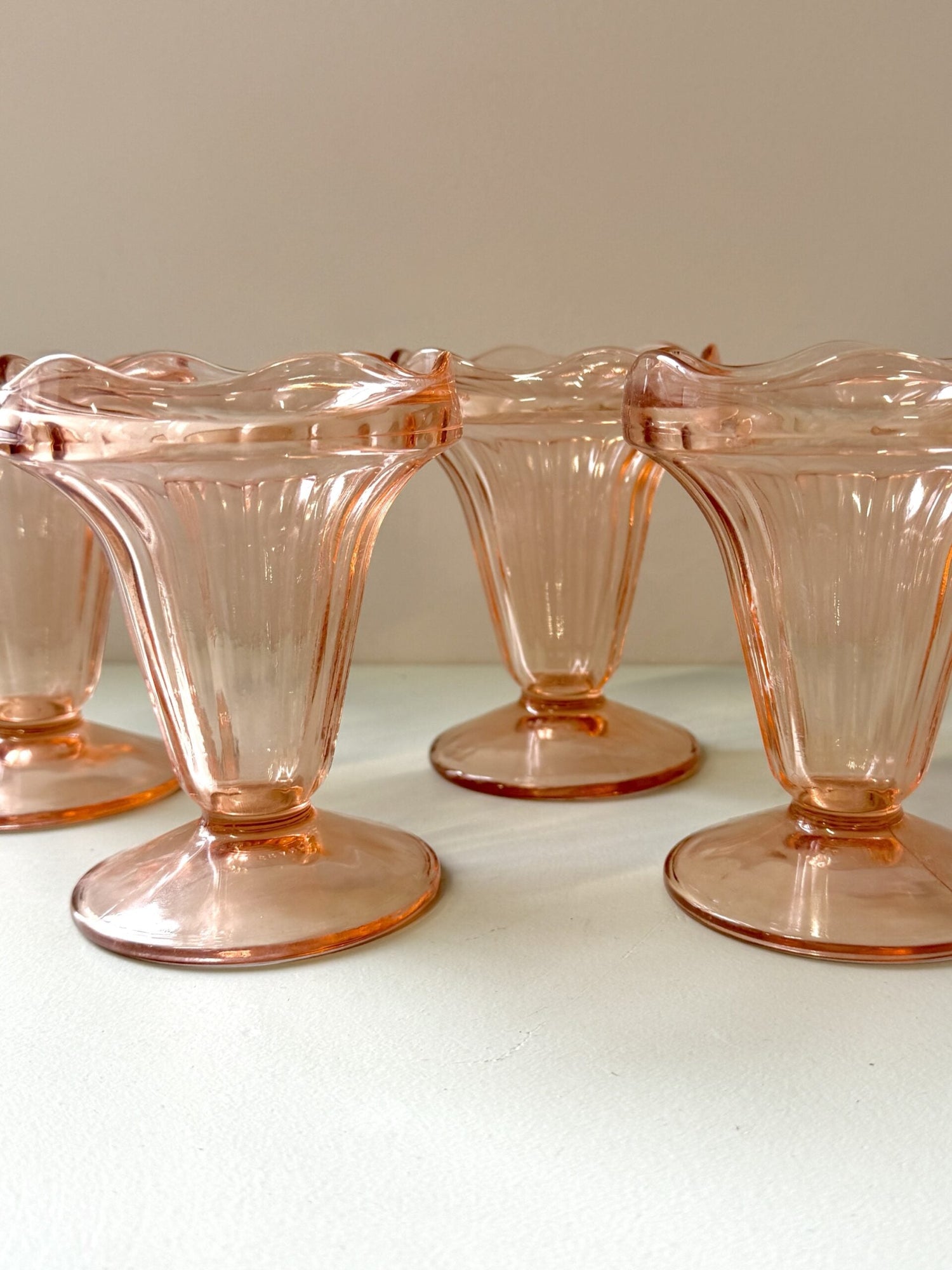 Série de coupes à glace en verre ciselé et coupelles en faïence dépareillées prêtes pour le service du dessert.