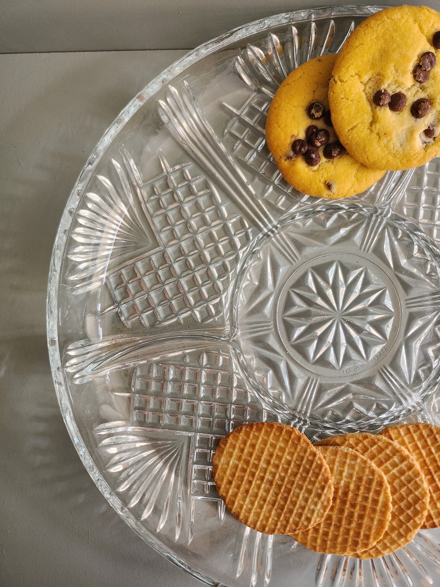 Gros plan sur un Plat en verre ciselé avec compartiment. 2 cookies et 4 gaufrettes